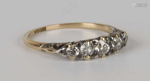 A gold and diamond five stone ring, mounted with a row of cushion shaped diamonds graduating in size