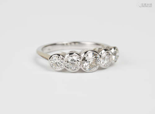 A platinum and diamond five stone ring, collet set with circular cut diamonds graduating to the