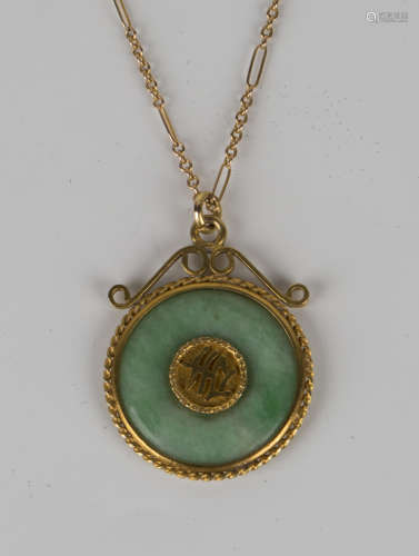 A Chinese gold and jade circular pendant, the centre with character motifs to the back and front