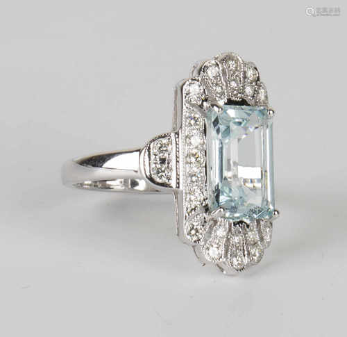 An 18ct white gold, aquamarine and diamond ring, claw set with a rectangular cut aquamarine within a