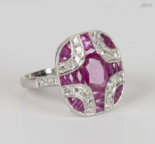 A platinum, ruby and diamond cluster ring, mounted with an oval cut ruby within a surround of