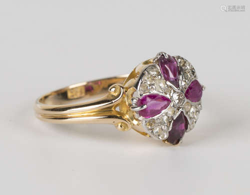 A gold, ruby and diamond circular cluster ring, claw set with four pear shaped rubies centred by a