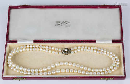 A two row necklace of graduated cultured pearls with a 9ct gold, green gemstone and half-pearl set