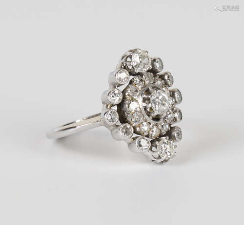 A diamond cluster ring, claw set with the principal circular cut diamond within a surround of