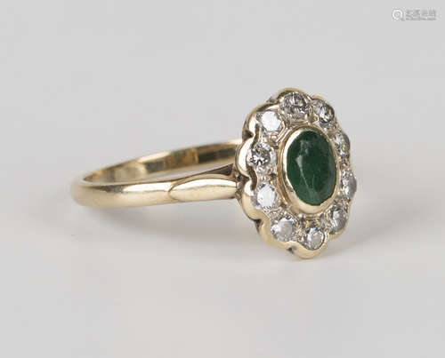 A 9ct gold, emerald and diamond oval cluster ring, mounted with the oval cut emerald within a