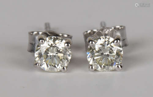 A pair of white gold and diamond single stone earstuds, each claw set with a circular cut diamond,