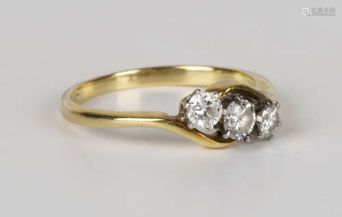 A gold, platinum and diamond three stone ring, claw set with a row of circular cut diamonds with the