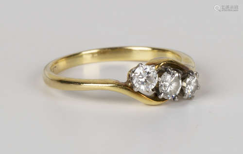 A gold, platinum and diamond three stone ring, claw set with a row of circular cut diamonds with the