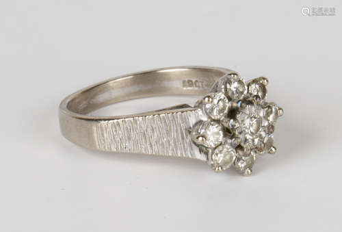 An 18ct white gold and diamond cluster ring, claw set with nine circular cut diamonds between