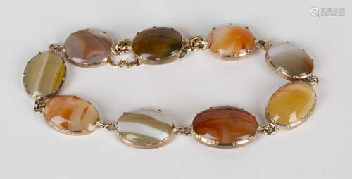 A gold and agate bracelet, claw set with nine oval slightly graduated vari-coloured agates, on a