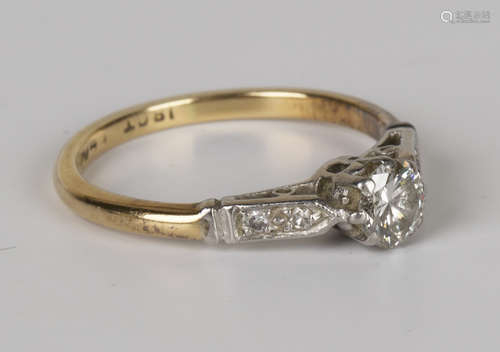 A gold, platinum and diamond single stone ring, claw set with a circular cut diamond between diamond