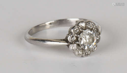 A platinum and diamond cluster ring, claw set with the principal cushion shaped diamond within a