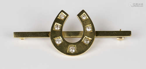 A gold and diamond bar brooch, designed as a horseshoe, mounted with seven cushion shaped