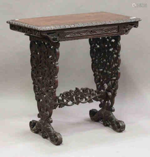 A 19th century Anglo-Indian rosewood work table, profusely carved with leaves and flowers, fitted