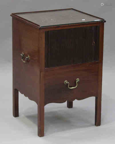 A George III mahogany bedside cabinet, fitted with brass carrying handles, the tambour front above a