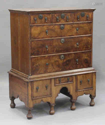 A George I walnut chest-on-stand, the moulded pediment above three short and three long drawers, the