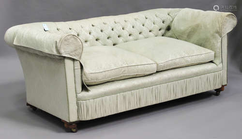 A George V Chesterfield settee, upholstered in a pale green damask, on bun feet and castors,