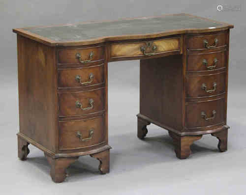 A 20th century mahogany serpentine fronted twin pedestal desk, the top inset with a gilt-tooled