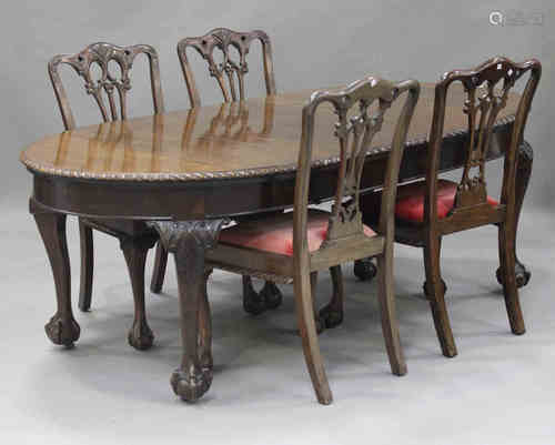 A George V mahogany extending dining table, fitted with two extra leaves, on carved cabriole legs