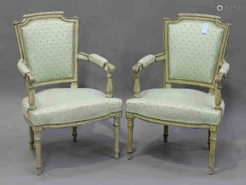 A pair of early 20th century Louis XVI style French cream and green painted fauteuil armchairs, each