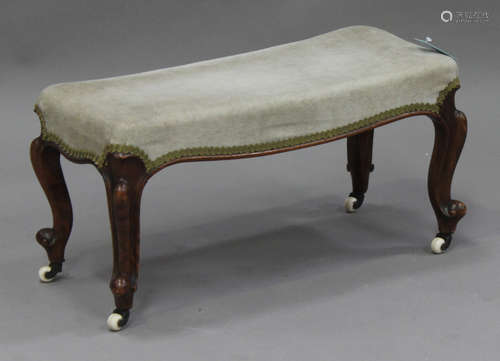 A Victorian walnut footstool, the overstuffed top upholstered in green velour, on cabriole legs