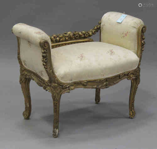 A late 19th century French giltwood and gesso window seat with carved foliate decoration, the