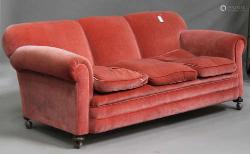 A George V three seat settee, upholstered in pink velour, on bun feet, height 81cm, width 200cm,