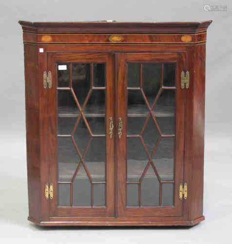 A George III mahogany hanging corner display cabinet with inlaid conch shell and fan paterae, fitted