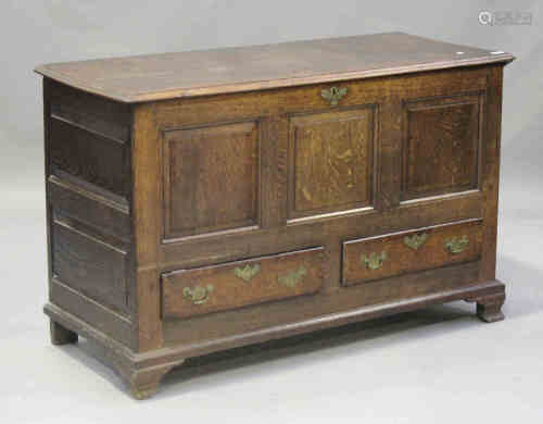 A George III oak mule chest, the hinged lid above a panelled and crossbanded front, fitted with