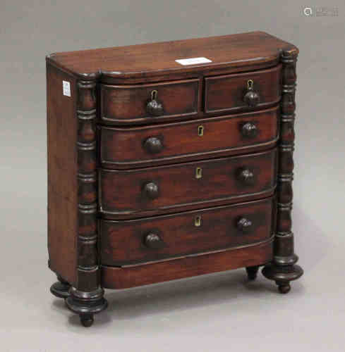 A Regency mahogany diminutive table-top chest of two short and three long drawers, on turned feet,