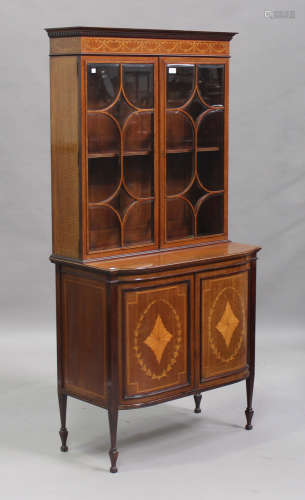 An Edwardian Neoclassical Revival mahogany and inlaid bookcase cabinet, the dentil moulded