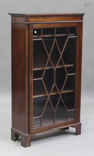 An Edwardian mahogany bookcase, the dentil moulded pediment above a single astragal glazed door,