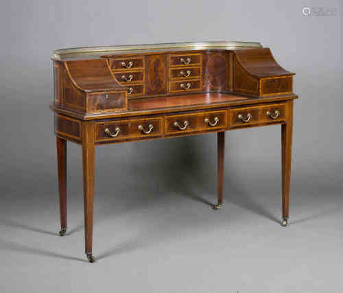 An Edwardian mahogany and satinwood crossbanded Carlton House desk, the gilt metal gallery top above
