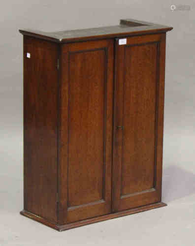 A late Victorian mahogany cabinet, fitted with a pair of panel doors revealing shelves and