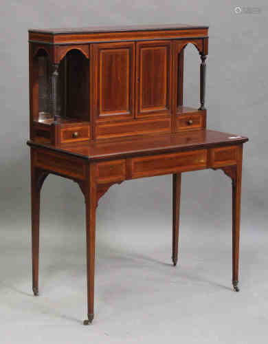 An Edwardian mahogany and satinwood crossbanded writing desk, the central cupboard revealing a
