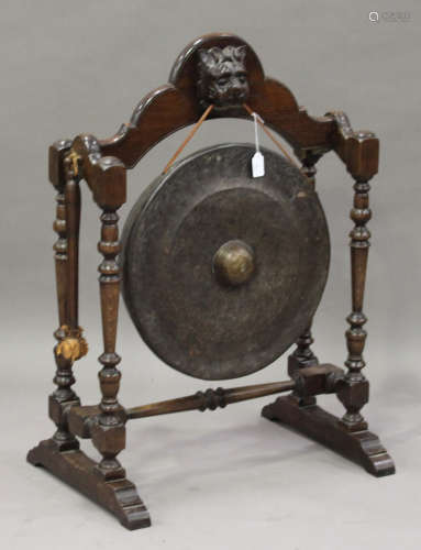An early/mid-20th century oak framed gong stand, on turned and block supports, fitted with a