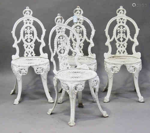 A set of four 20th century cast aluminium garden chairs, the pierced foliate backs on downswept