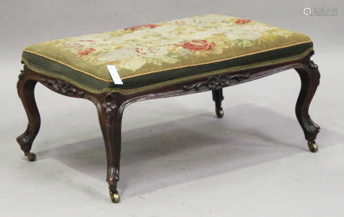 A mid-Victorian rosewood rectangular stool, the needlework seat above a carved frieze, raised on