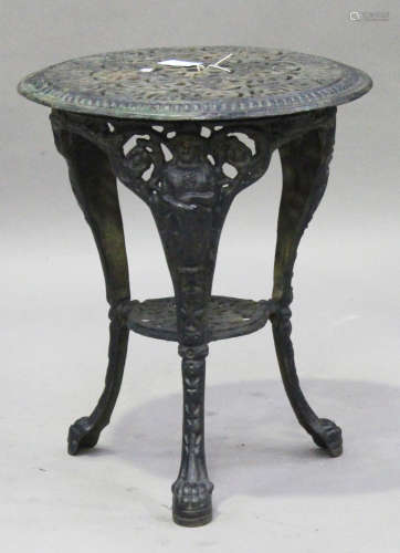 A Victorian cast iron circular garden table, the pierced top on three figural legs united by an