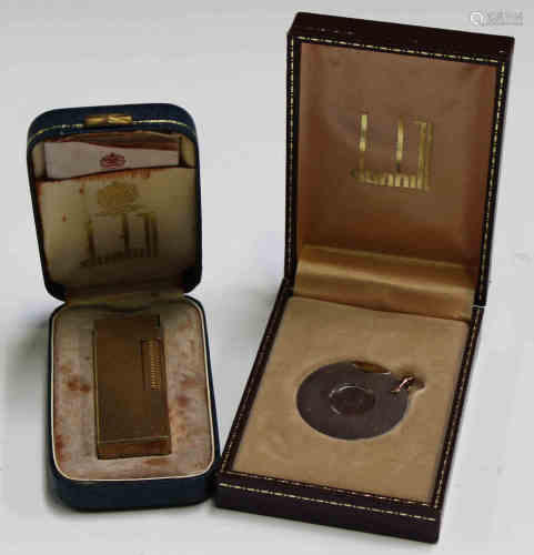 A Dunhill gilt metal pocket lighter, cased, and a Dunhill cigar cutter, cased.Buyer’s Premium 29.