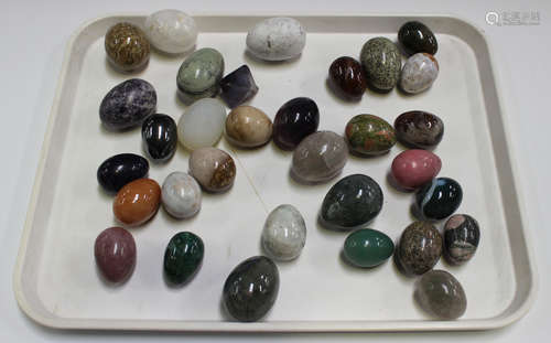 A collection of polished hardstone eggs, contained within a wooden box.Buyer’s Premium 29.4% (