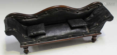 A Victorian mahogany framed diminutive model of a scroll back settee, upholstered in black