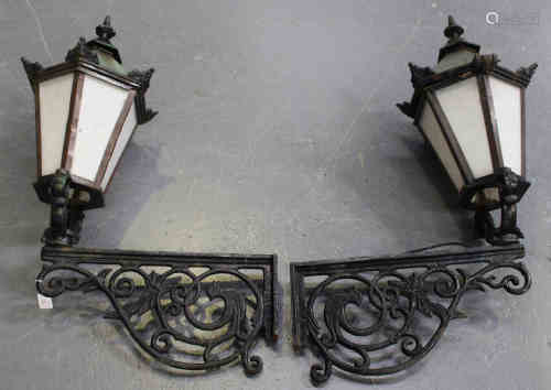 A pair of 20th century Continental cast iron wall mounted street lanterns with foliate scrolling