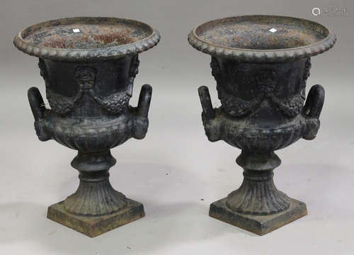 A pair of 20th century cast iron garden urns of half-reeded campana form, the bodies with floral