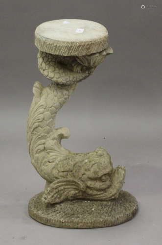 A 20th century cast composition stone garden stand in the form of a Regency dolphin, height 62cm.