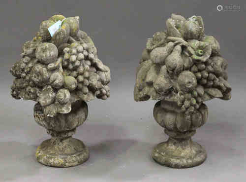 A pair of French cast composition stone garden ornaments, modelled in the form of fruit-laden