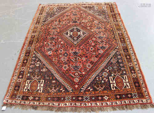 A Shiraz rug, South-west Persia, mid-20th century, the red field with a hooked medallion,