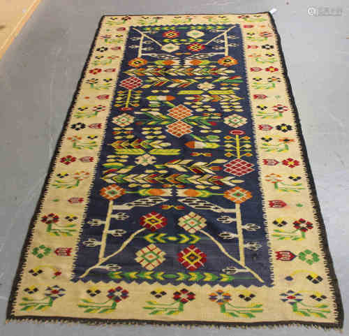 A Romanian kelhim rug, mid/late 20th century, the mid blue field with overall geometric flowers,
