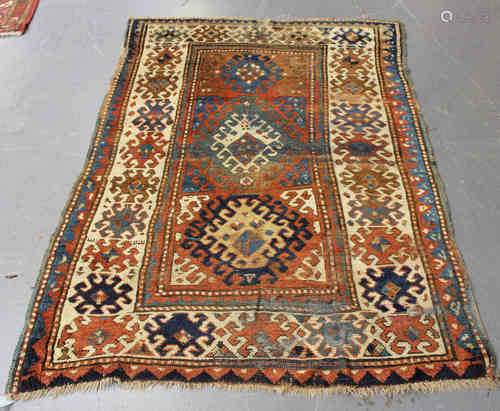 A Bordjalou Kazak rug, West Caucasus, early 20th century, the shaded terracotta field with three