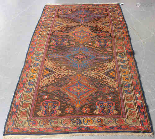 A Caucasian sumak rug, early 20th century, the dark chestnut field with four hooked medallions